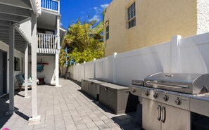 An outdoor patio with a barbecue grill, storage cabinets, and a white fence. - Beach Rd, 300ft to Beach Access & 500ft to Siesta Key Village, 1bdr (Siesta Key)