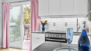 Une cuisine moderne avec des meubles blancs, une cuisinière à gaz et un coin repas comprenant une table et des chaises.