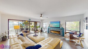 Amplia sala de estar con un gran sofá, chimenea y televisor.