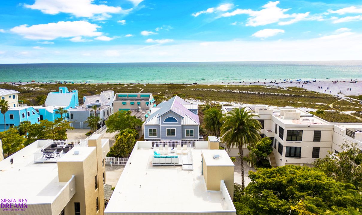 A coastal hotel with multiple buildings, a pool area, and a beach view.