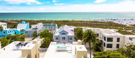 A coastal hotel with multiple buildings, a pool area, and a beach view.