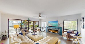 Amplia sala de estar con un gran sofá, chimenea y televisor.