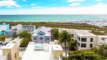 A coastal hotel with multiple buildings, a pool area, and a beach view.