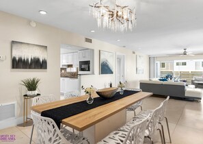A modern kitchen with white cabinets, a wooden island, and a chandelier. - Entire Building, Sundeck w/ Ocean view, 20ft to Beach Access, 500ft from Village (Siesta Key)