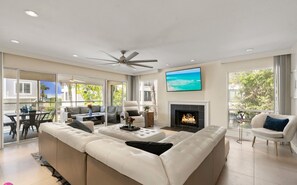 A spacious living room with a large sectional sofa, a fireplace, and a television mounted on the wall. - Entire Building, Sundeck w/ Ocean view, 20ft to Beach Access, 500ft from Village (Siesta Key)