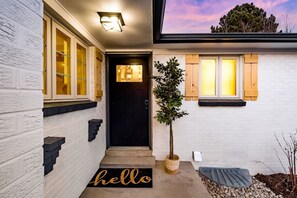 A modern house with a black door, a 'hello' mat, and a small tree in a pot. - Château des Fleur-Min to Wash Park & DT Denver (Denver)