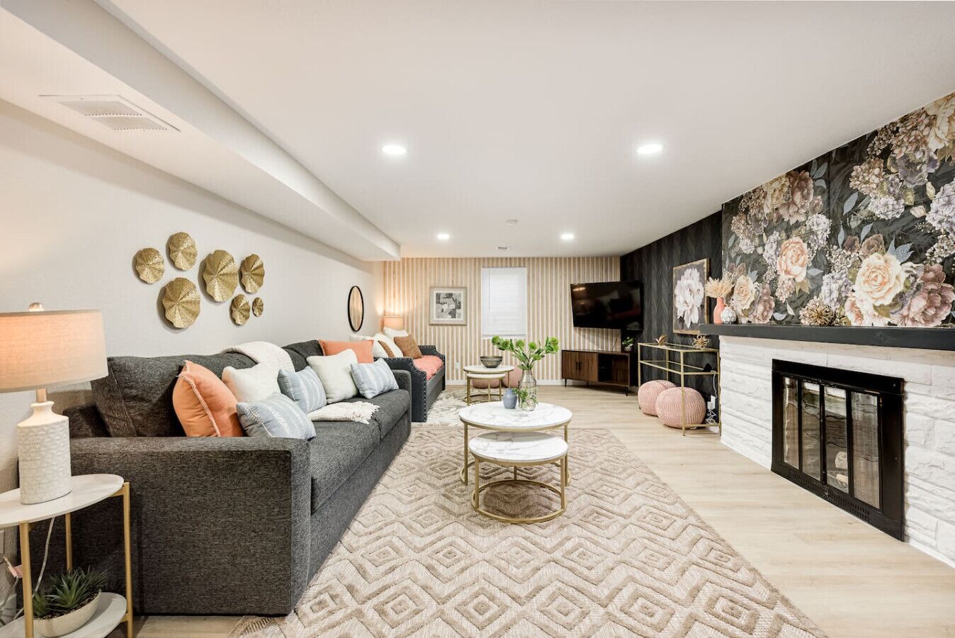 A modern living room with a grey sofa, a round coffee table, and a fireplace.