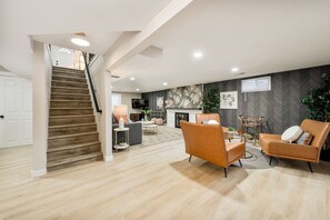 A spacious living area with a staircase, a fireplace, and modern furniture. - Château des Fleur-Min to Wash Park & DT Denver (Denver)