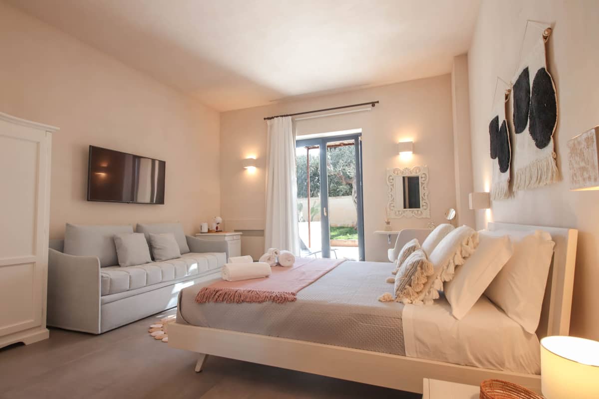 Une chambre à coucher avec un lit, un canapé, une fenêtre et une porte.