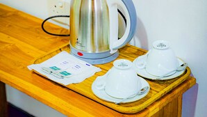 A stainless steel kettle on a wooden table with a WiFi password sign above it. - Sunbird's Home  (Udawalawa)