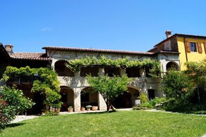 A courtyard with a building featuring arched windows and a tiled roof. - Nice apartment in Trassenheide (Bonvicino)