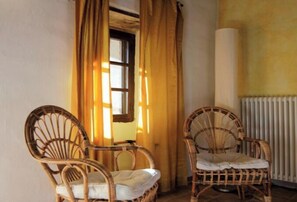 A room with two wicker chairs, a window with curtains, and a radiator. - Nice apartment in Trassenheide (Bonvicino)