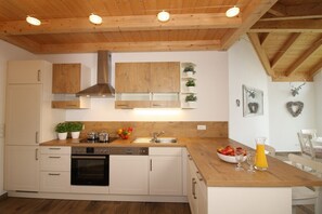 Eine moderne Küche mit Holzschränken, einer Edelstahl-Dunstesse und einer Holzarbeitsplatte.