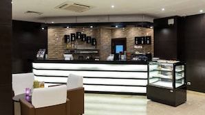 Un área de recepción moderna con mostrador, asientos y una vitrina.