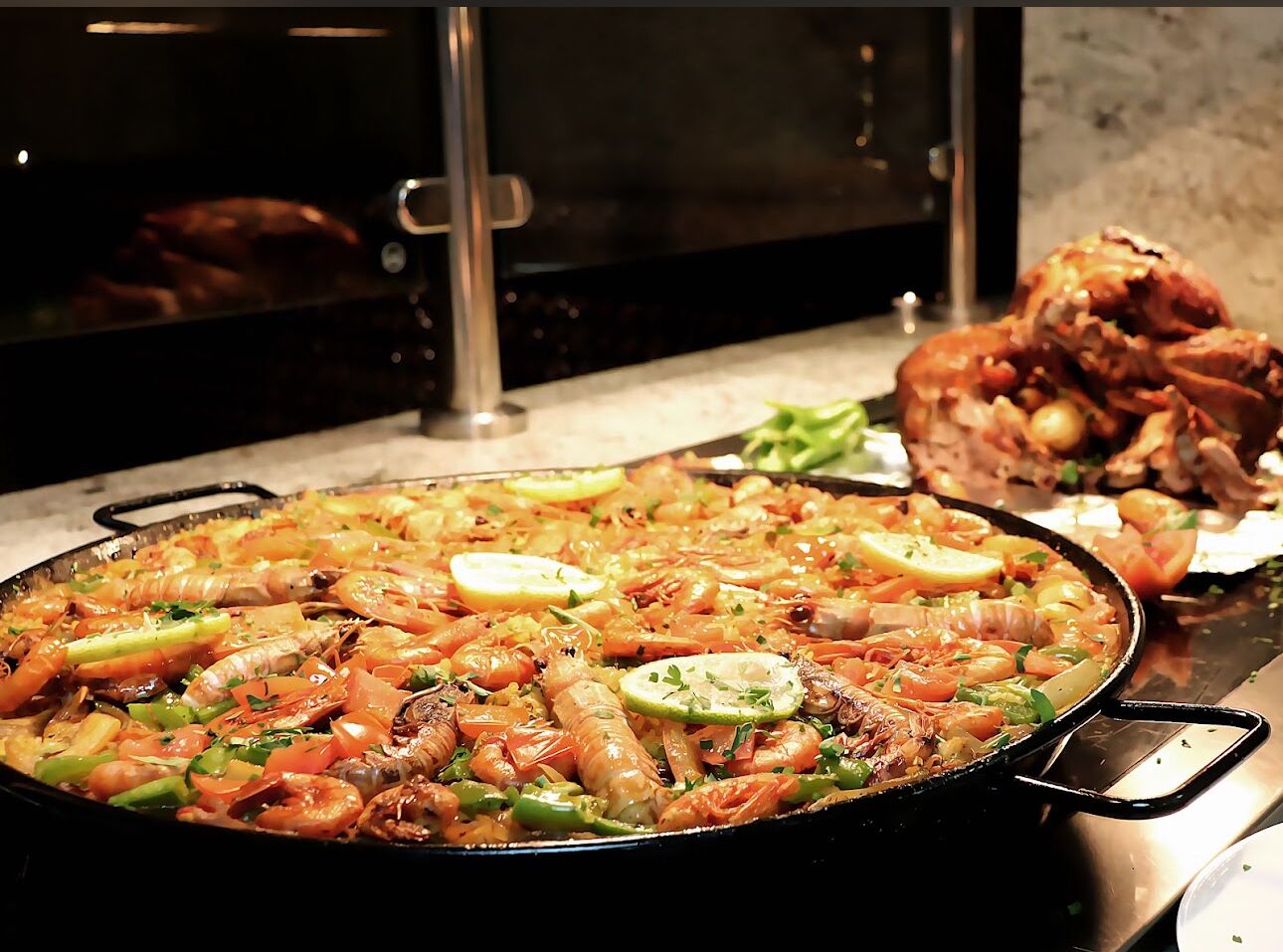 Eine große Paella mit Meeresfrüchten auf einem Herd.