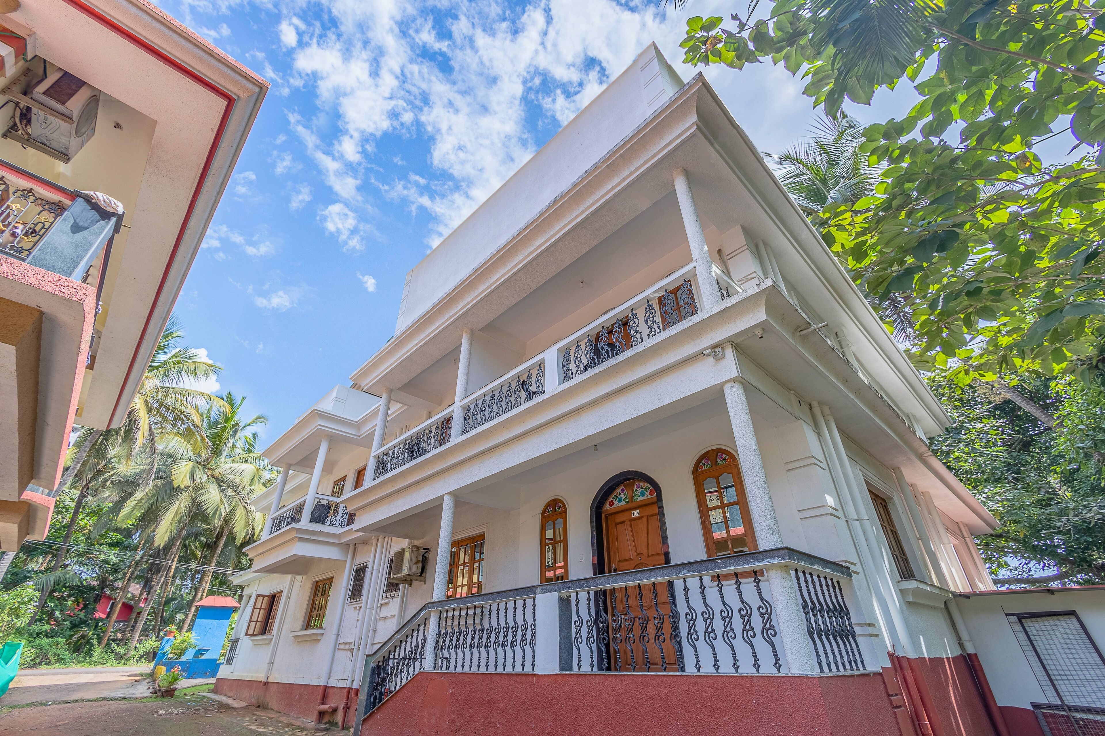 A two-story building with a balcony and a staircase leading to the entrance.