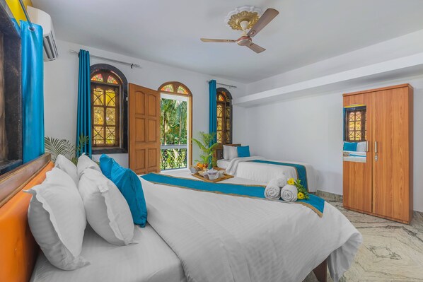A hotel room with two beds, a wooden wardrobe, and a window with curtains. - The Sequeira Guest House (Majorda)