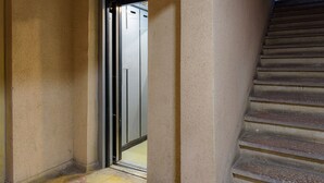 A hallway with a door leading to a stairwell. - Cozy 1-bedroom apartment in enjoyable Bucharest with WiFi, AC (București)