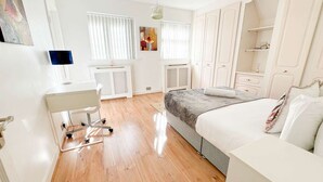 A modern bedroom with a bed, a desk, and a wardrobe. - Zen 8-Bedroom Den in Edgbaston (Birmingham)