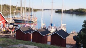 Een jachthaven met verschillende boten afgemeerd, een rood gebouw en een gazon op de voorgrond.