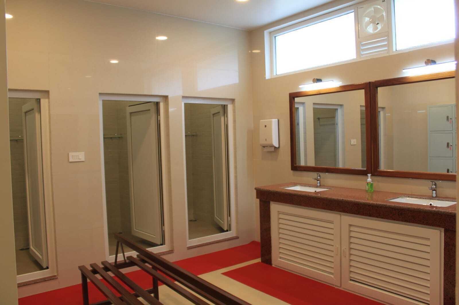 A bathroom with a large mirror, two sinks, and a shower area.