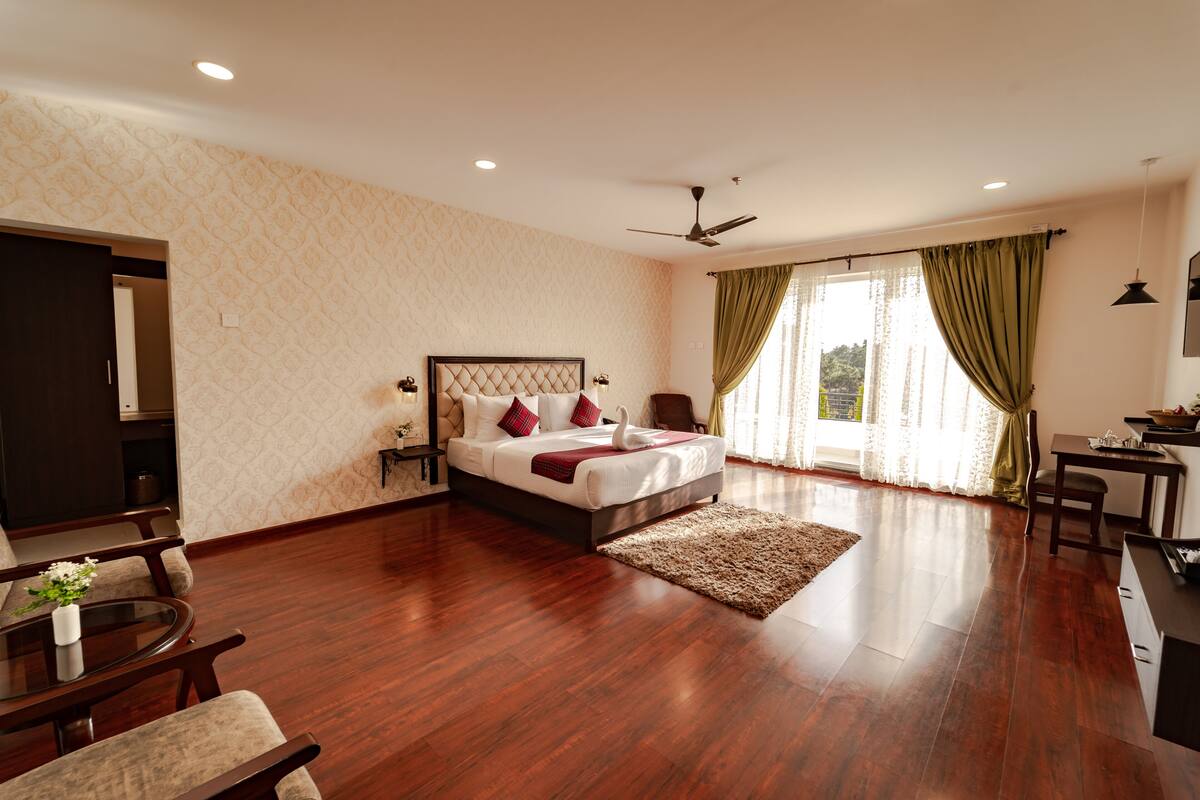 A spacious bedroom with a large bed, a desk, and a chair.