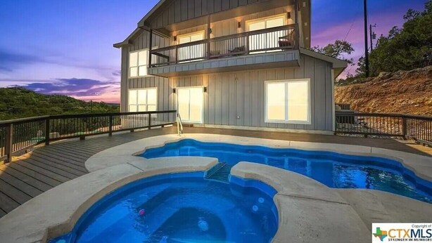 Una casa de dos pisos con piscina y terraza.