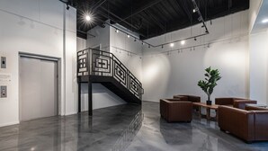 Un intérieur moderne avec un escalier, un coin salon et une porte.