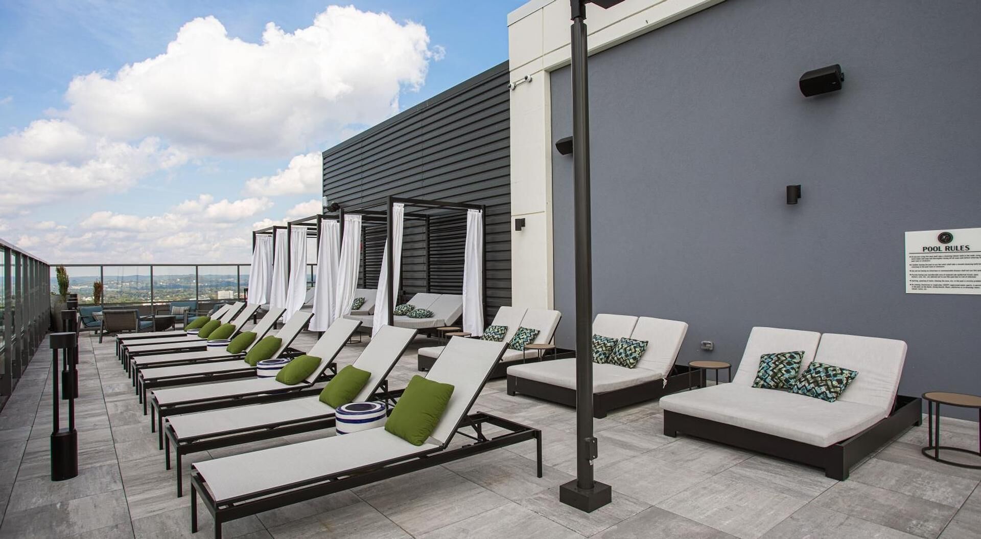 Un espace de détente aménagé sur le toit, avec des chaises longues et un coin salon au bord de la piscine.