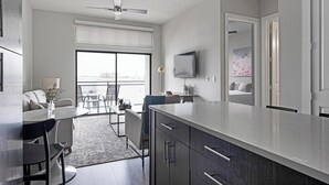 Eine moderne Küche mit einer großen Kochinsel, ein Essbereich mit Aussicht und ein Wohnbereich mit Balkon.