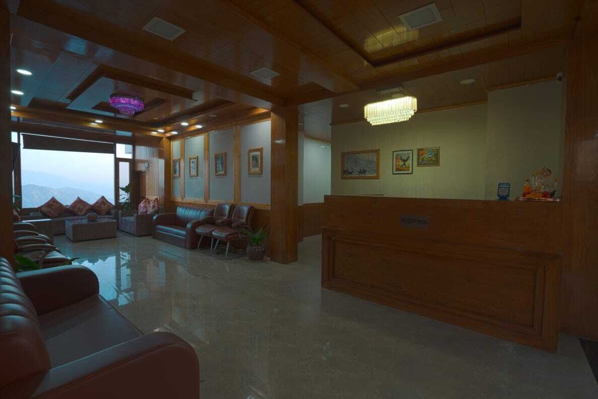 A reception area with a wooden reception desk, several chairs, and a large window offering a view of the mountains.