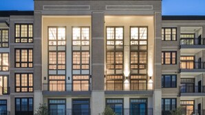 Un immeuble à plusieurs étages doté de grandes fenêtres et de balcons.