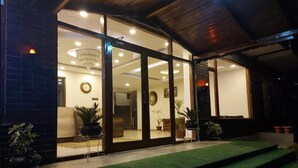 A modern building with large glass doors leading to an interior space. - The Spruce Mansion Manali (Manali)