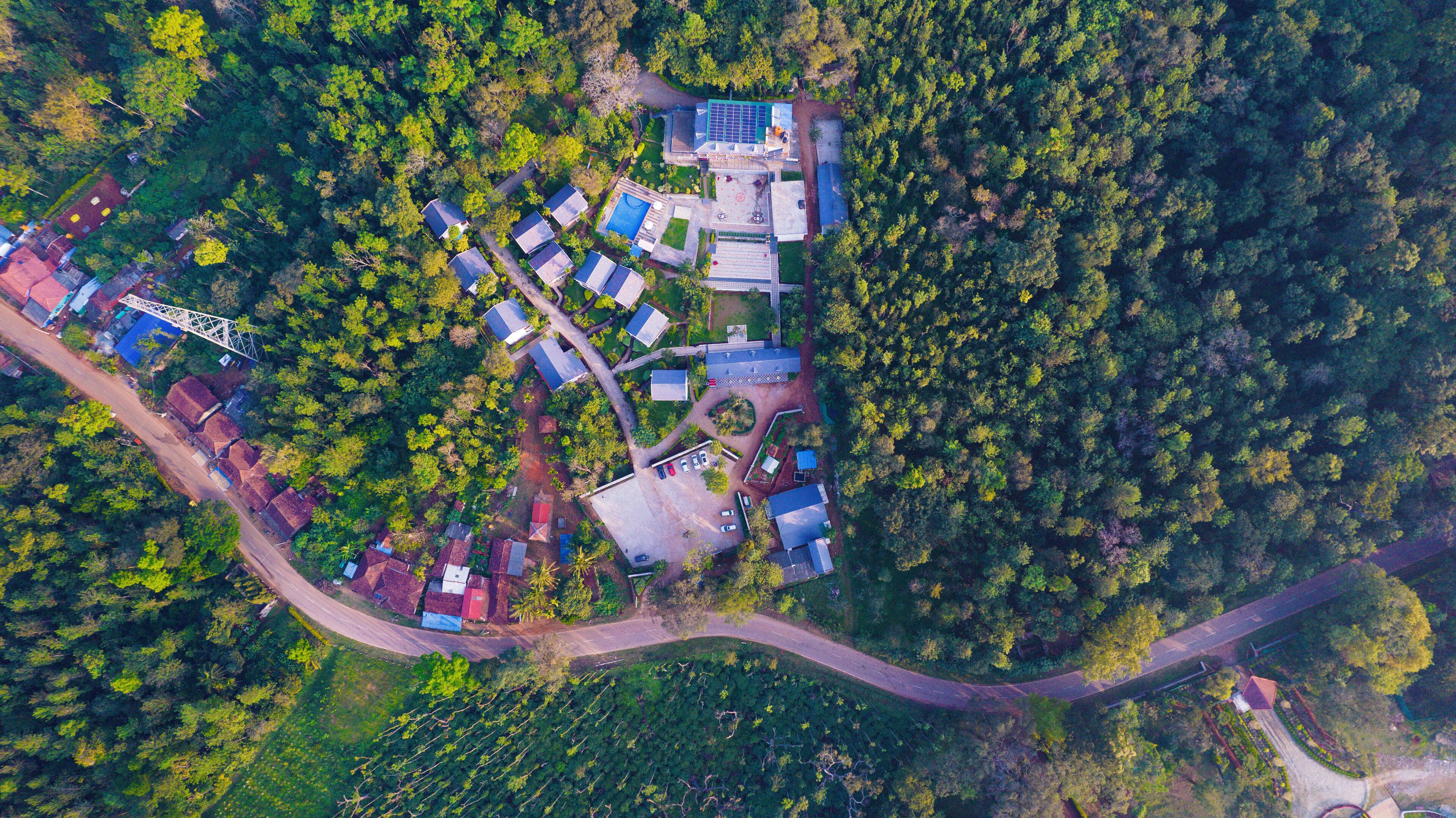 An aerial view of a residential area with multiple houses, a bridge, and a road.