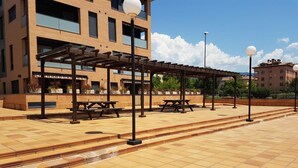 An outdoor patio area with picnic tables and a pergola structure.