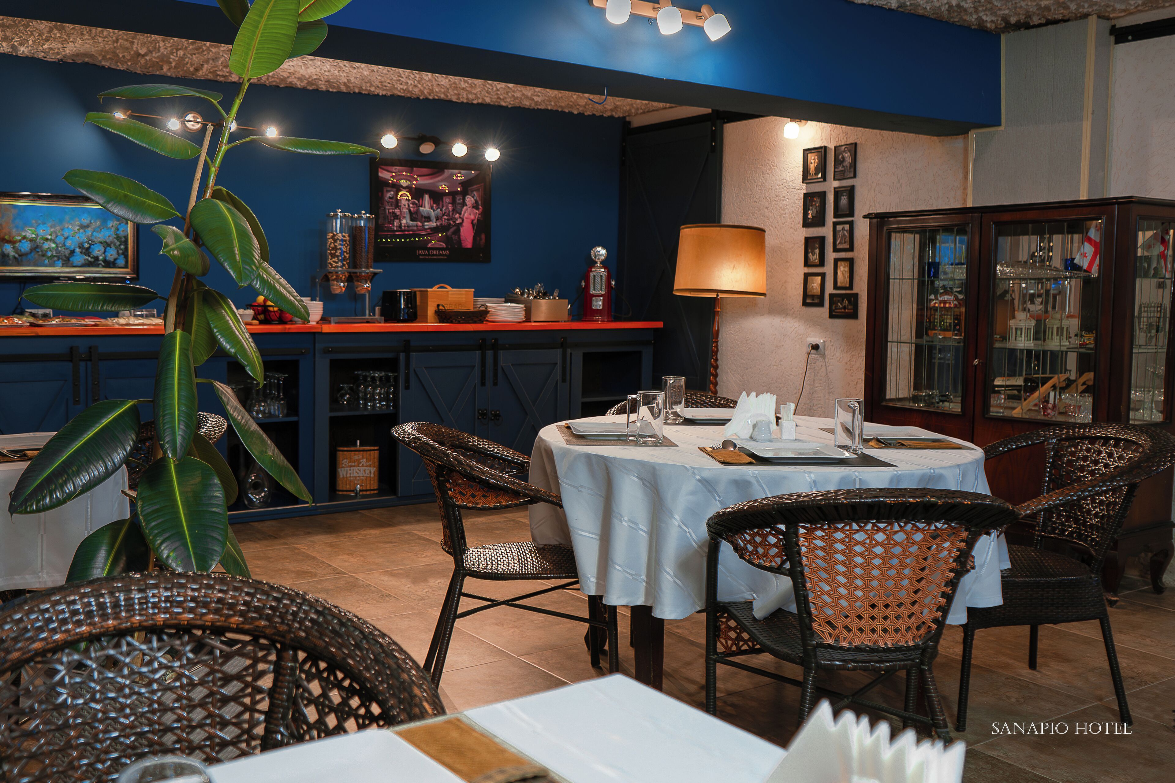 A restaurant with wicker chairs, a bar area, and a dining table set for two.