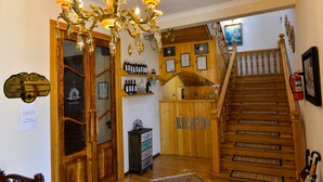 A hotel lobby with a grand chandelier, wooden staircase, and a reception desk. - hotel sanapiro (Kutaisi)
