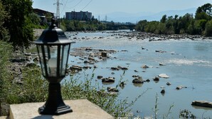 A river with rocks and a lamp post in the foreground. - hotel sanapiro (Kutaisi)