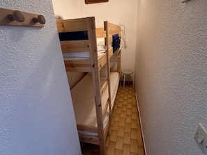 A narrow room with bunk beds, a small table, and a wall-mounted light fixture. - Studio + Cabin with Parking and Terrace - Beach Access (Port Camargue)