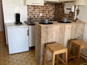 A compact kitchenette with a refrigerator, a sink, and a small countertop. - Studio + Cabin with Parking and Terrace - Beach Access (Port Camargue)