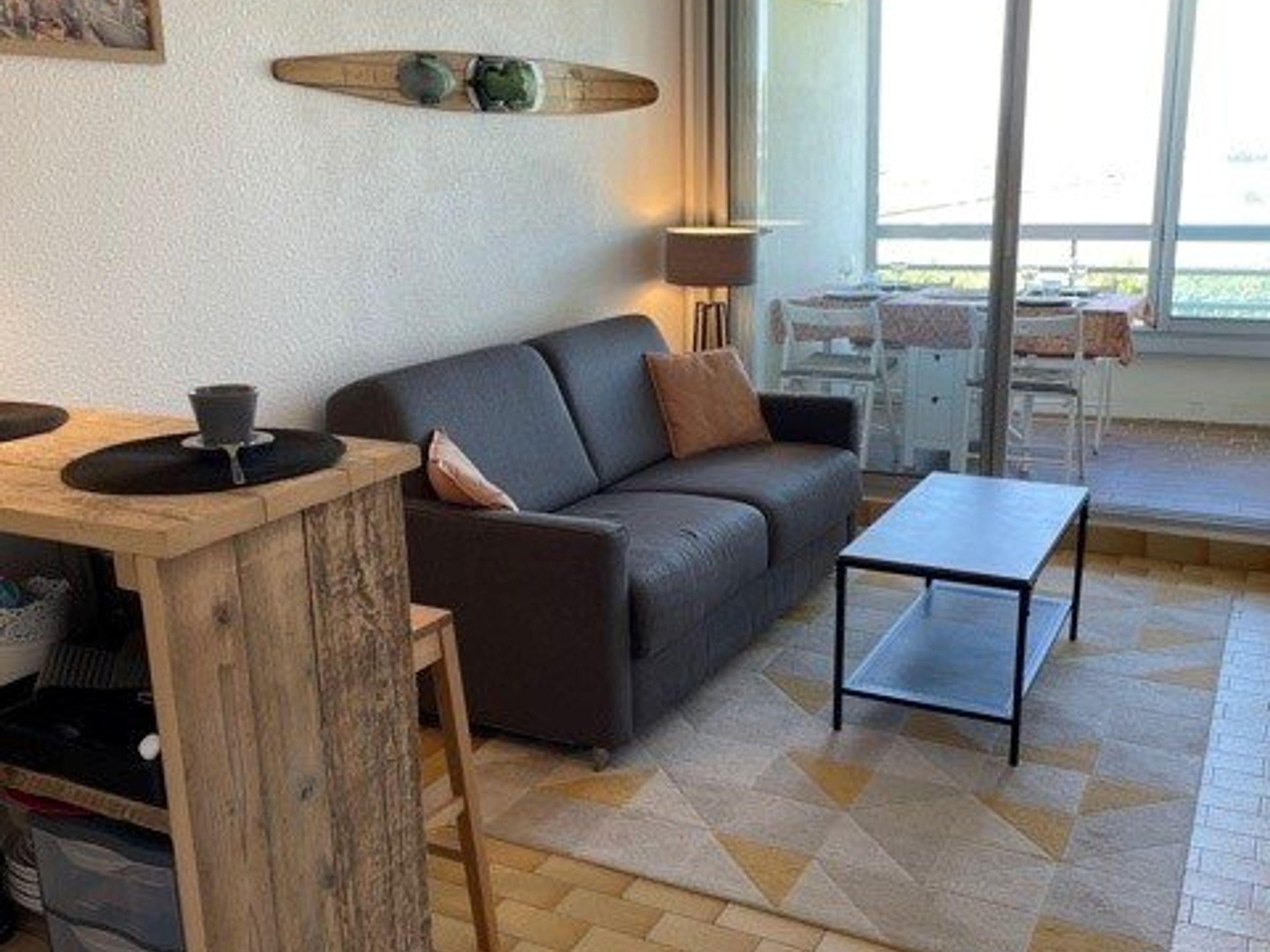 A modern living room with a sofa, a coffee table, and a wooden side table.
