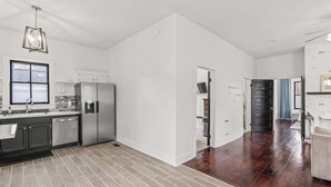 A spacious kitchen with modern appliances, a large window, and a hardwood floor. - Cozy Duplex Near DT, King, 3 TVs, Walk To Dine (Columbia)