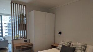 A modern bedroom with a bed, a desk, and a wardrobe. - Trendy Studio at the Barracks on Bree (Cape Town)