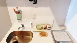 A kitchen with a stainless steel sink, a scale, and various kitchen utensils and dishes. - suikakan heianjingumae (Kyoto)