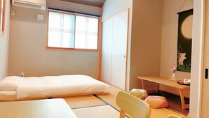 A compact room with a bed, a desk, and a chair. - suikakan heianjingumae (Kyoto)