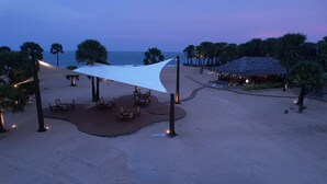 A beachside resort with a covered seating area, palm trees, and a view of the ocean. - LA PALMERA (Kadaladi)