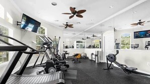 A gym with treadmills, exercise bikes, and ceiling fans. - Kissimmee townhouse w/ shared pool & BBQ (Kissimmee)