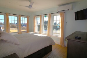 Un dormitorio con cama, escritorio y televisión.