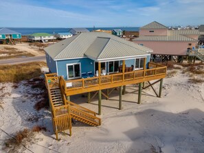 A beach house with a wooden deck and a staircase leading to the entrance. - Goin' Coastal - 2703 Bienville 4 Bedroom Home by RedAwning (Dauphin Island)