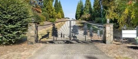 A gated entrance with a deer and tree silhouette mural.